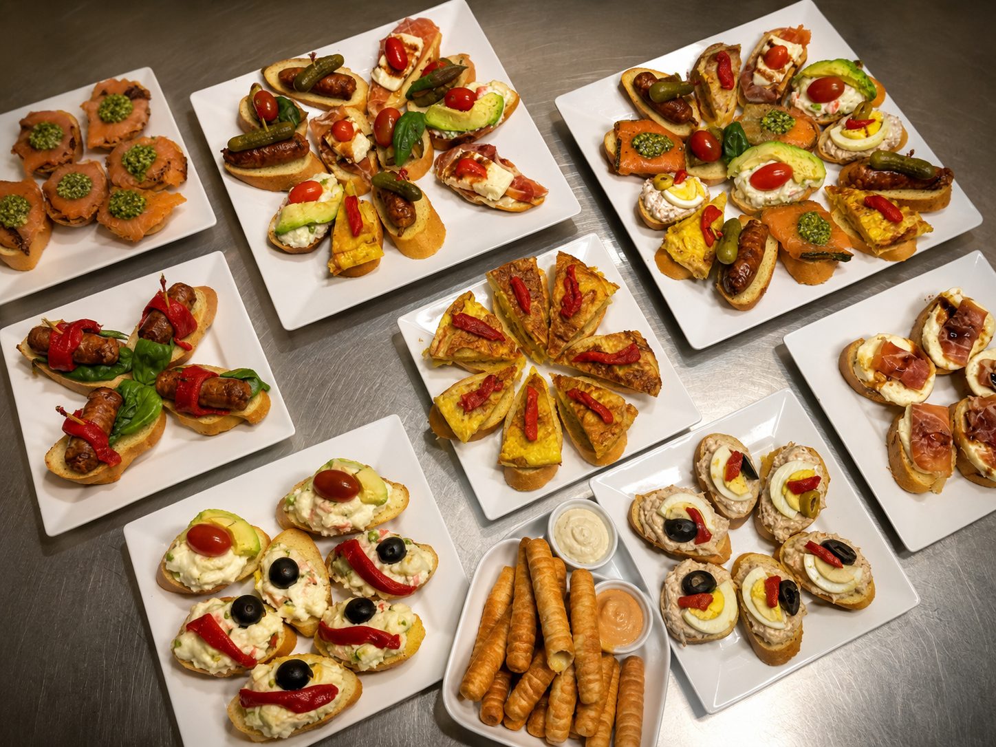 Renzo's catering spread — montados and pinchos trays: salmon, chistorra, tortilla española, tuna and egg